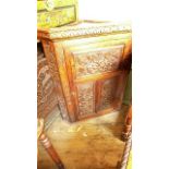 Antique corner cupboard with intricate carvings to sides and the three panel fronts,