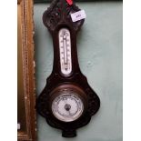 Aneroid wall barometer in carved oak case with thermometer dial