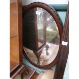 Oval bevel edged wall mirror in beaded frame