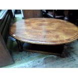 Solid oak oval low coffee table (36" x 48") on turned feet united by undershelf