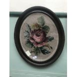 Woolwork embroidery of a rose in an ornate beaded oval frame