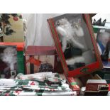Box of Christmas decorations incl. an unused 16" sitting santa, fibre optic house, tablecloths etc.