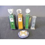 Four die-cast miniature petrol pumps, two in BP livery plus a Redex badge.