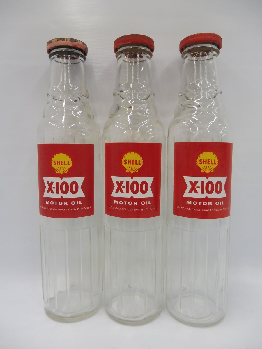 Three Shell X-100 pint oil bottles with tops.