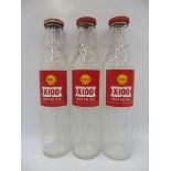 Three Shell X-100 pint oil bottles with tops.