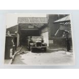 A large scale black and white photograph of a Motor Coach Garage, showing a Gilford charabanc loaded