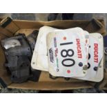 A box of rear number plate holders and racing plates.