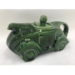 A green glazed ceramic teapot in the form of a car.