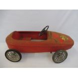 A tinplate pedal car, appears to be depicting a Ferrari grand prix car from the 1960s.