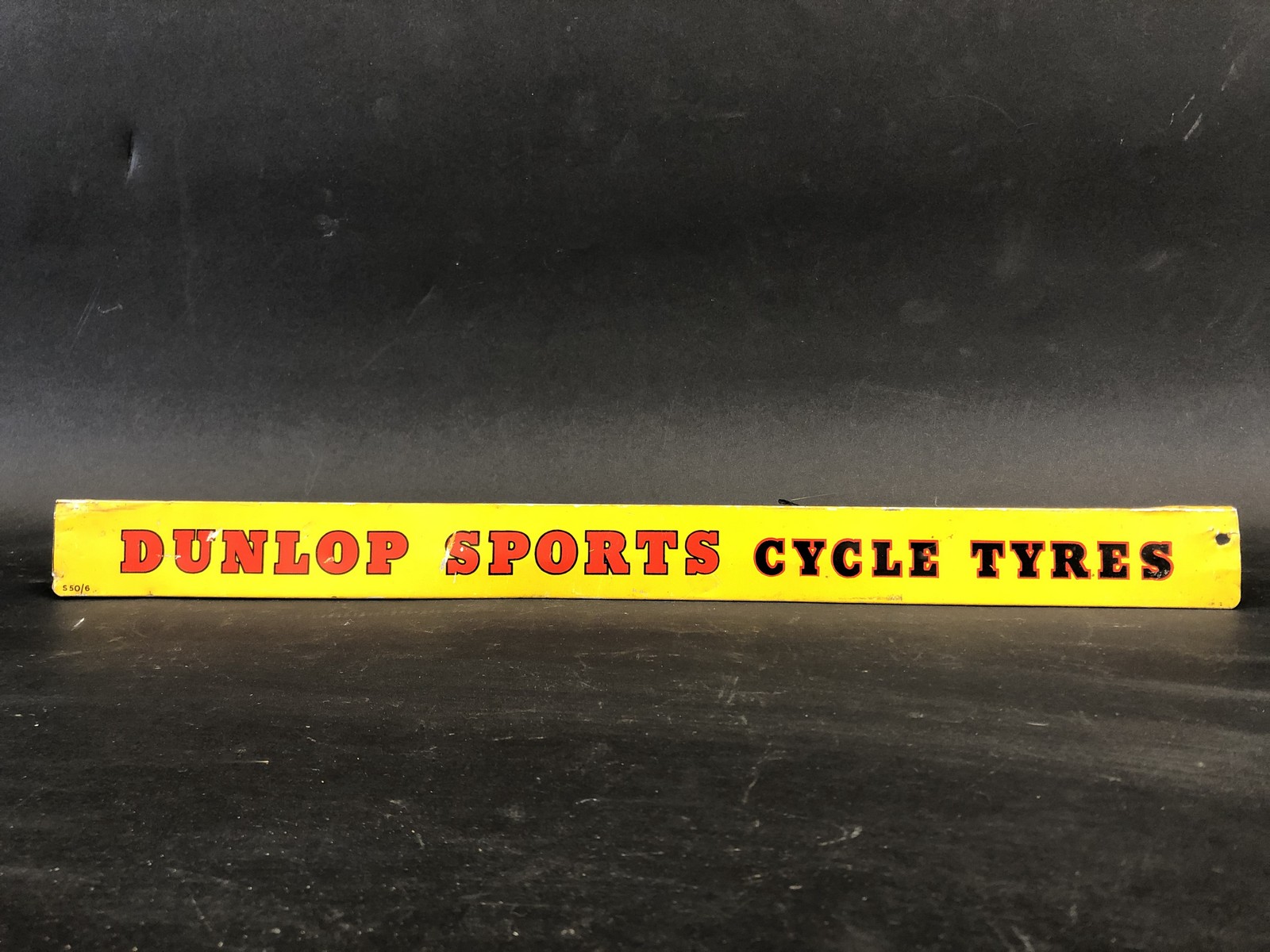 A Dunlop Sports Cycle Tyres shelf strip.