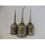 Three Kaye's Patent brass mounted polished steel oilers with tall spouts.