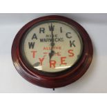 A Warwick Tyres circular wall clock.