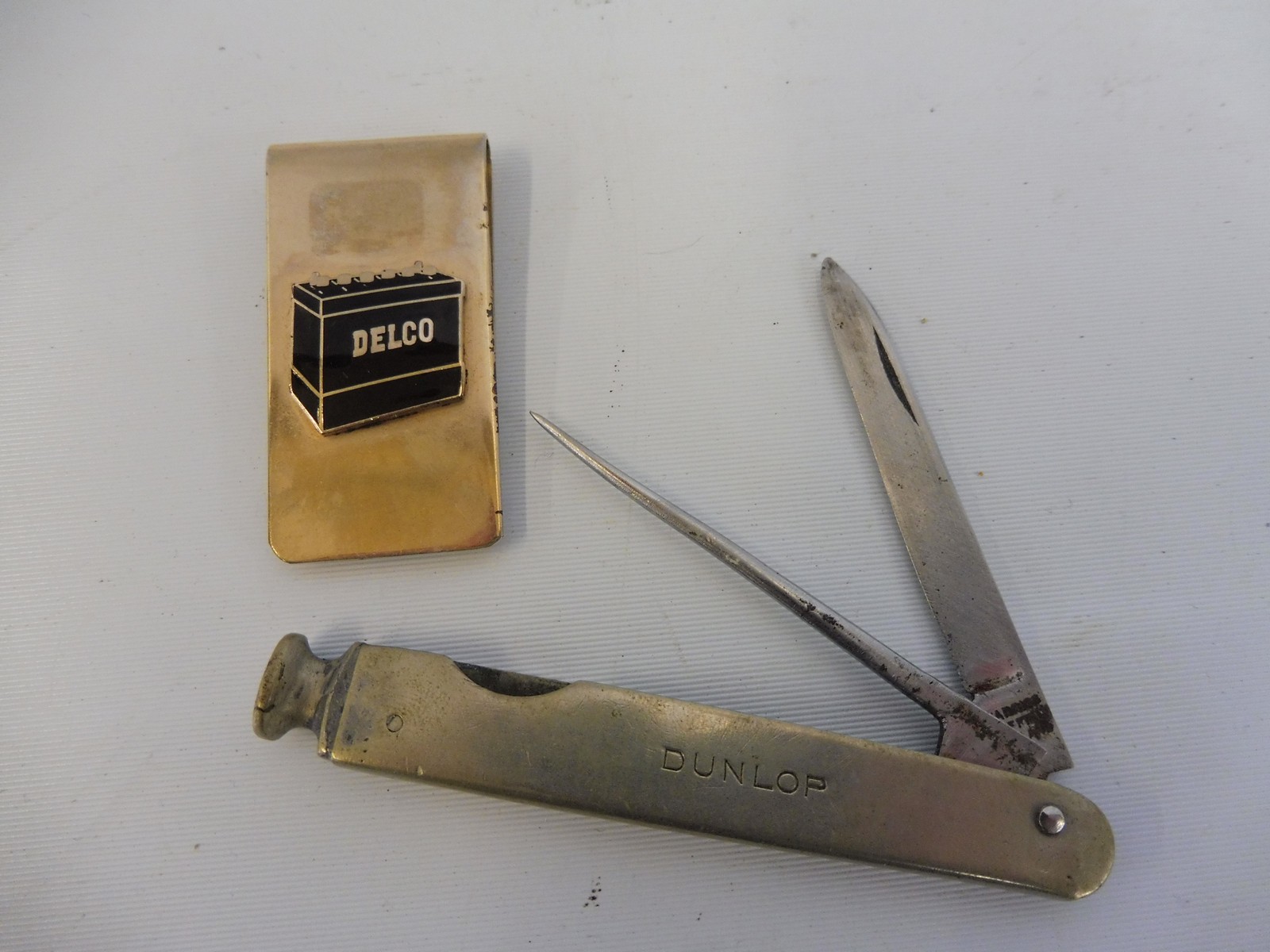 A Dunlop penknife and a Delco batteries money clip.