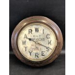 A Warwick Tyres circular advertising wall clock with pendulum and key.