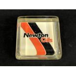 A Newton Oils glass advertising garage paperweight.