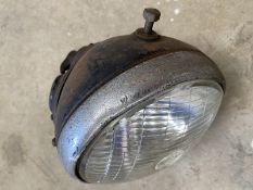 A vintage Lucas 7" motorcycle headlamp with amp and switch, in good condition.