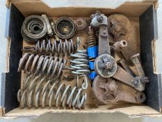 A tray of motorcycle dampers, springs and speedometer drives.