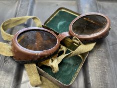 A pair of vintage military motorcycle goggles, in original tin case.