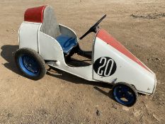A large pedal car, appears scratch built circa 1950s, in the style of a single seater racing car.