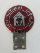 An International Doghouse Club car badge in red enamel with kennel design to the centre.