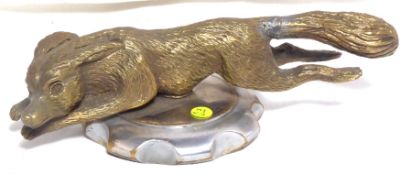 A detailed brass mascot in the form of a running fox, mounted on a radiator cap.