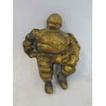 A small brass seated Michelin Mr. Bibendum figure.