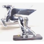 An accessory mascot in the form of a stylised pegasus, display base mounted.