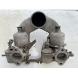 A pair of 1 1/2" SU vertical carburettors, with air cleaning casting.