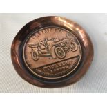 A Daimler embossed copper ashtray.