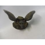 A vintage car accessory mascot in the form of a winged bird of prey.