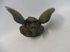 A vintage car accessory mascot in the form of a winged bird of prey.