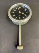 A Jaeger Swiss eight day car clock with long winding stem below.