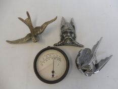A Swallow car mascot, a Rover Viking radiator badge, a Mack mascot and a temperature gauge.