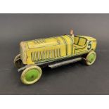 An English-made clockwork tinplate model of a 1920s racing car, complete with driver.