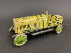 An English-made clockwork tinplate model of a 1920s racing car, complete with driver.