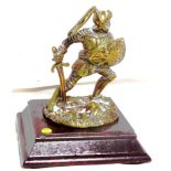 An accessory mascot in polished brass, in the form of a knight in armour.