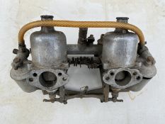 A pair of 1 3/8th" SU carburettors, inclined, on inlet manifold, Mowog.