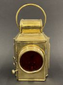 A Howes & Burley Ltd. polished brass rear lamp with red glass lens.