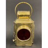 A Howes & Burley Ltd. polished brass rear lamp with red glass lens.