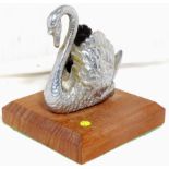 An accessory mascot in the form of a swan, on a display base.