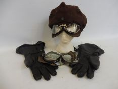 A pair of motoring goggles and gauntlets plus an unusual peaked cap with integral goggles.