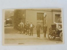 An original postcard depicting an early garage scene with a Gilbert & Barker T8 petrol pump beside