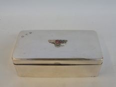 A silver plated rectangular cigarette box with applied Bentley badge to the top.
