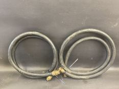 Two black rubber hoses with brass ends.