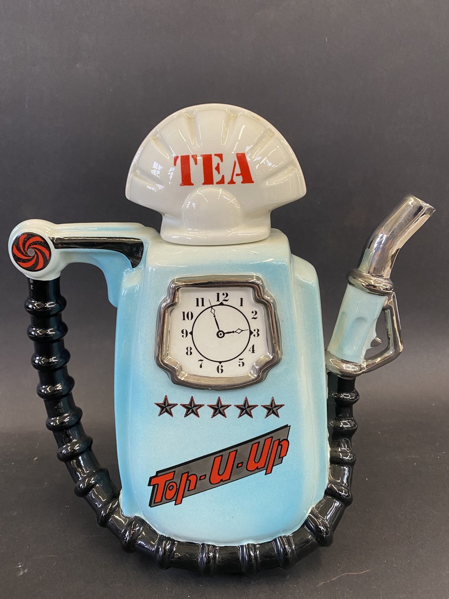 A novelty teapot in the form of a petrol pump.