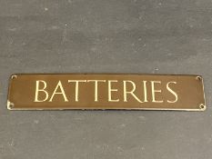 A small brown and cream coloured enamel sign for 'Batteries', 12 x 2 1/2".