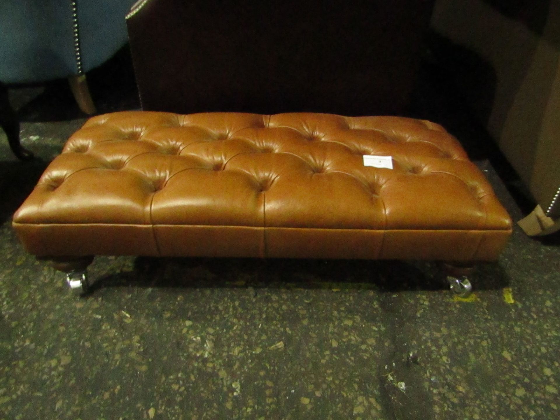 Leather foot stool on castors, ex display