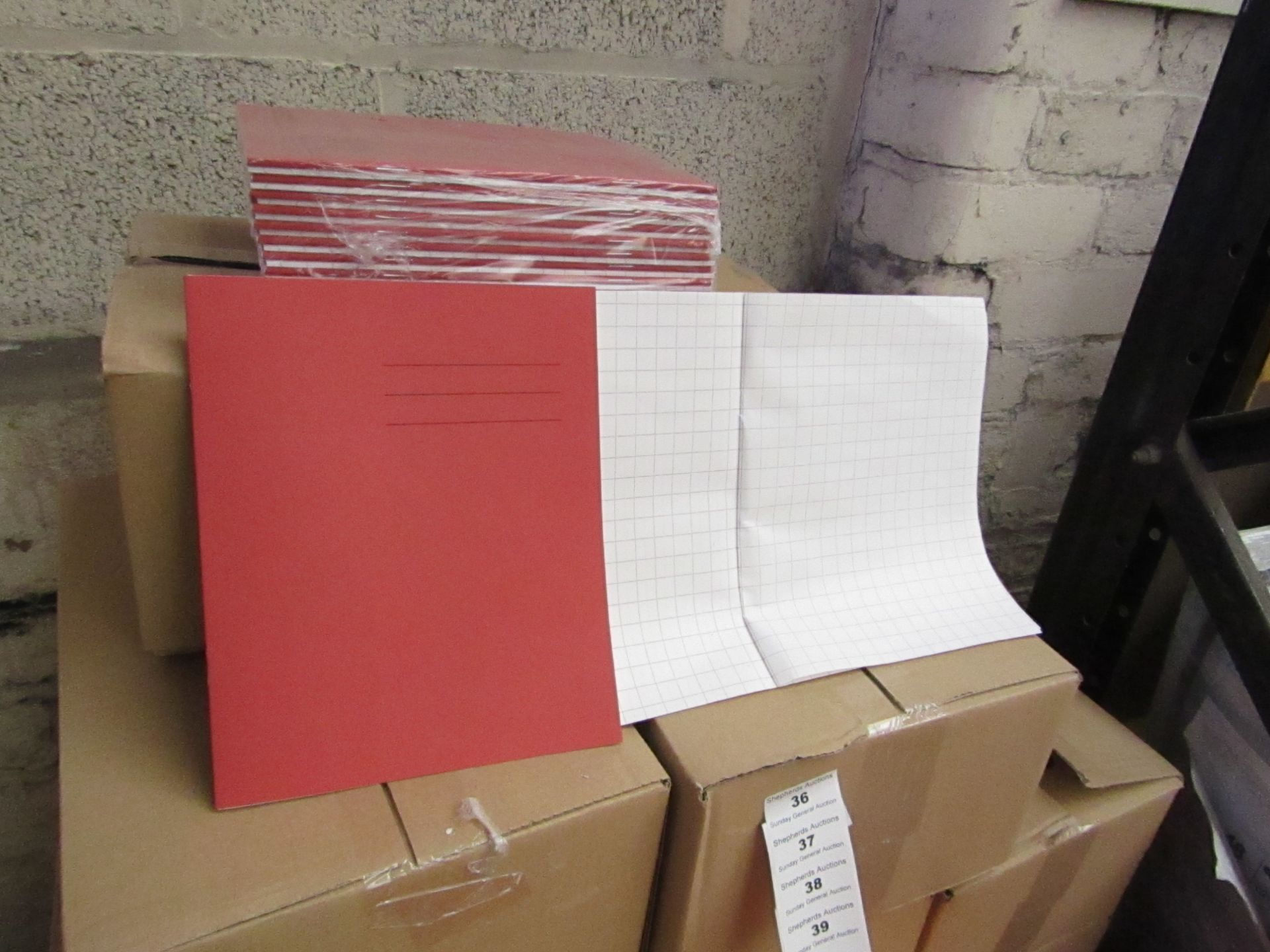 100x Red coloured exercise books, new and boxed.