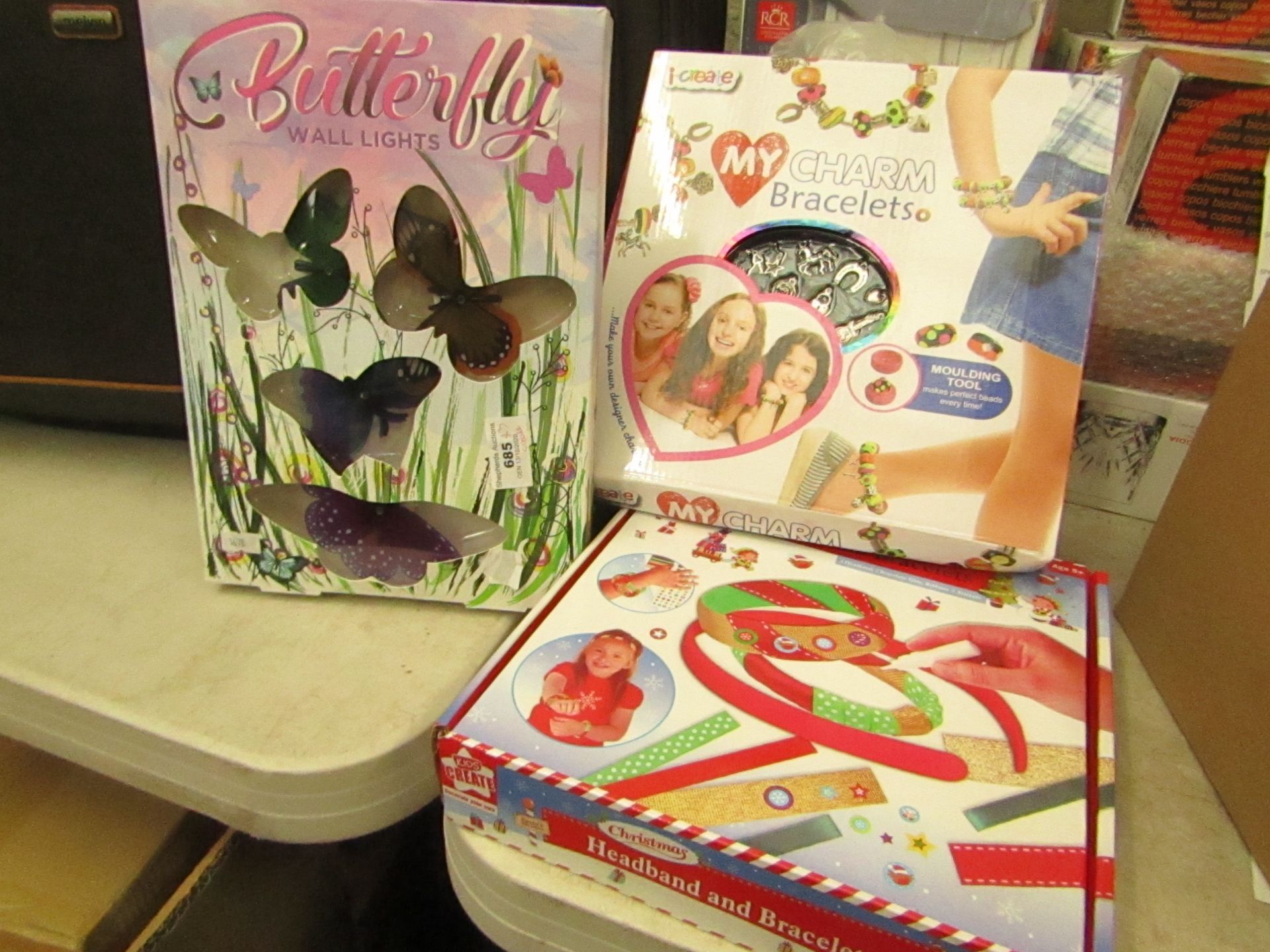 3x Items being Butterfly wall lights, a Charm Craft kit and a Xmas headband and bracelet kit, all