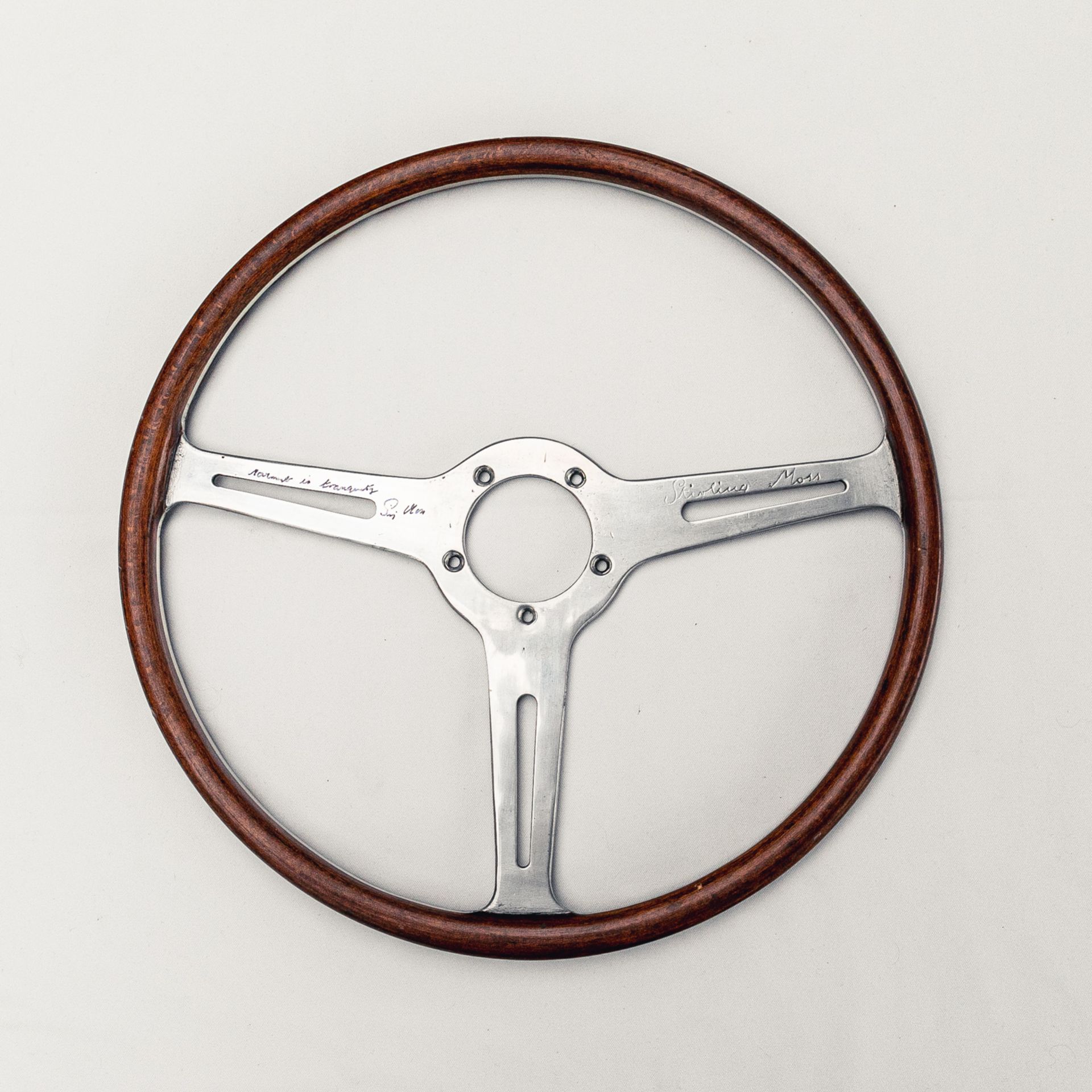 A race used period steering wheel hand signed by Stirling Moss